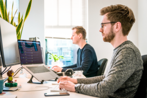 Two men stare at their computer screens at the office, trying to determine what white space is and how to find it.